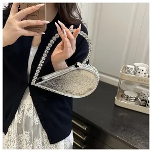 Detail der silbernen herzförmigen Abendtasche mit Strass-Griff und plissierter Oberfläche