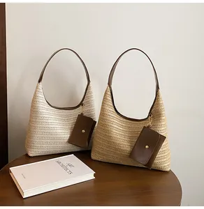 Detailed view of hand-woven hobo bags in beige and natural straw with faux leather handles