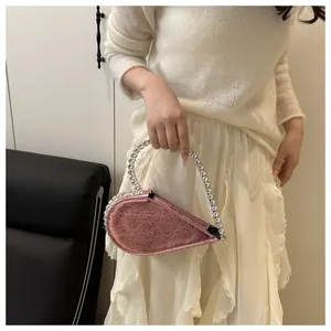 Detail der roségoldenen Herz-Handtasche mit funkelndem Kristallgriff für Abendpartys