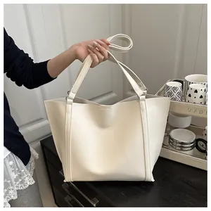 Detail of minimalist cream white tote bag with dual handles and long shoulder strap