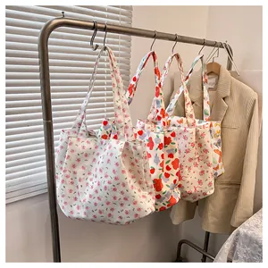 Detailed view of floral canvas tote bags with rose prints hanging on a rack