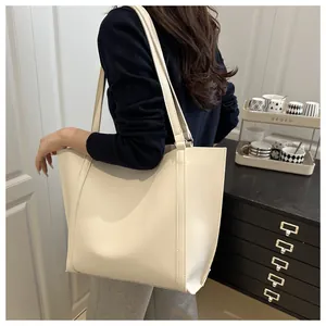 Side view of a cream large capacity tote bag worn over the shoulder for daily commuting