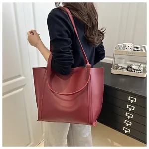 Detail of red leather tote bag showing spacious design and smooth matte finish texture