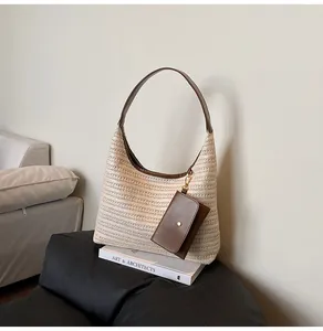 Detail of straw woven tote with brown leather trim and matching small pouch