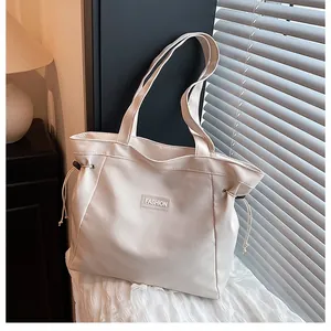 Gros plan détaillé d'un grand sac cabas beige à cordon avec l'inscription Fashion