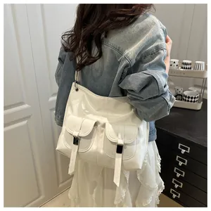 Polished white leather shoulder bag with decorative black metallic buckles on front pockets