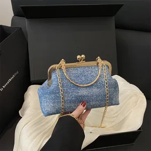 Elegant blue denim shell bag with gold chain strap in a luxury gift box packaging