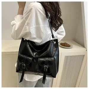Detail of high-gloss black motorcycle tote bag with double front buckle pockets