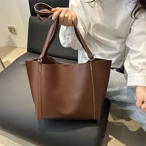 Classic dark brown vintage tote bag in matte faux leather with wide handles and strap