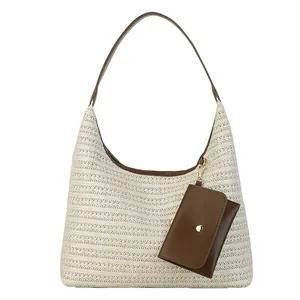 Straw woven tote bag in cream white with brown leather straps and small hanging coin pouch