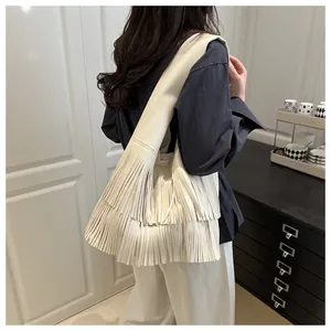 Detail of multi-layered long fringes on a cream leather tote bag for a vintage look