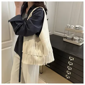 Detailed view of the bohemian tassel fringe and litchi grain texture on the shoulder bag