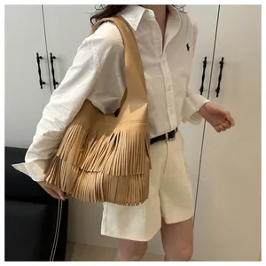 Detail of multi-layer fringe tassels on brown pebbled faux leather bohemian shoulder bag