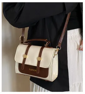 Close-up of vintage beige crossbody bag with fashion print and gold buckle detail