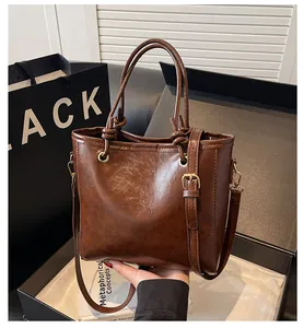 Vue détaillée de la texture du cuir ciré marron caramel sur le sac à main de luxe