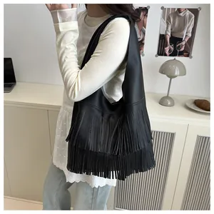 Close-up of the black pebble leather texture and layered fringe on this bucket bag