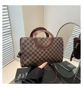 Close-up of vintage brown monogram handbag with unique round leather handle and strap