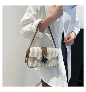 Detail of woven cream shoulder bag featuring brown leather trim and diamond metal buckle