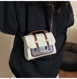 Detailed view of the vintage crossbody bag with gold Fashion print and metal studs
