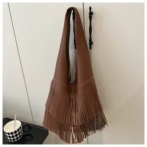 Close-up of brown litchi pattern leather shoulder bag with long bohemian tassels