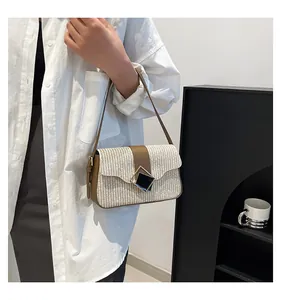 Detail of cream woven texture and dark brown leather strap with diamond metal buckle