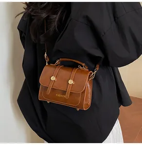 Detail view of brown vintage satchel with golden buckle and adjustable strap