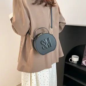 Fashionable black round crossbody bag with embossed SM letters and Saffiano texture