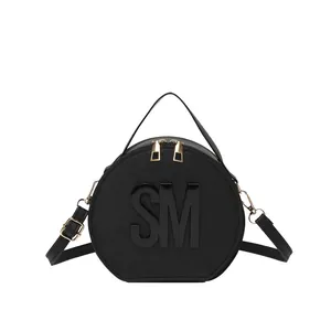 Modern black circular shoulder bag with gold zipper and textured letter logo