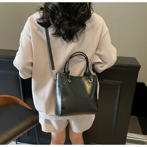 Vue arrière détaillée d'un sac seau en cuir PU noir brillant porté par un mannequin