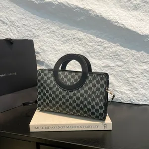 Chic blue-grey monogram handbag with unique round handles and a black shoulder strap