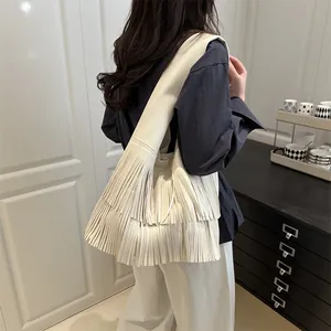 Retro fringe hobo bag in cream leather shown on shoulder for large capacity casual style