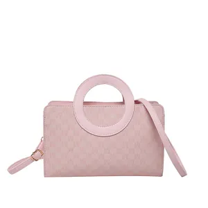 Pink rectangular crossbody bag with circular metal handle and monogram pattern