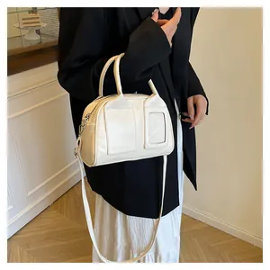 Detail der cremefarbenen Boston-Tasche aus Leder mit Vordertaschen und Kartenfach