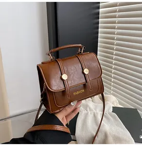 Close-up of brown vintage handbag with gold hardware and high-gloss leather texture