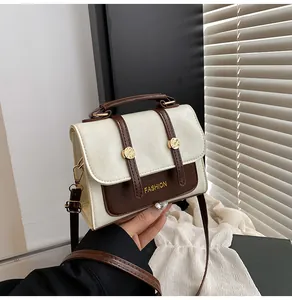 Detail of vintage square bag showing faux leather texture and golden metal buckle