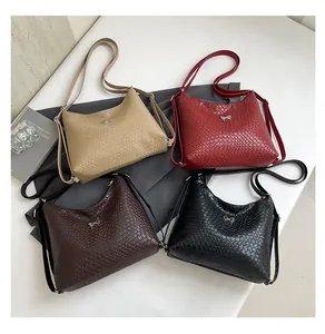Détail de quatre sacs bandoulière texturés en beige, rouge, marron et noir