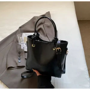 Détail du sac cabas en similicuir noir avec poignées nouées et œillets dorés