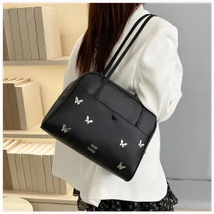 Détail du sac cabas en cuir mat noir avec papillons argentés et doubles bretelles d'épaule