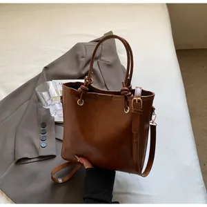 Vue détaillée du sac cabas marron vintage avec poignée nouée et ferrures en métal doré
