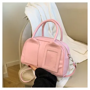 Detailansicht einer rosa Boston-Tasche mit Klarsichttasche, Griffen und Schultergurt