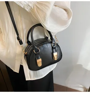 Gedetailleerd zicht op zwarte mat PU-leren mini Boston tas met goudkleurige metalen details