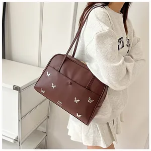 Détail d'un sac cabas marron foncé avec papillons métalliques et logo imprimé