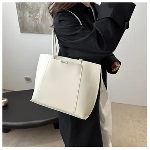 Détail du sac cabas en cuir PU blanc avec coutures superposées et barre métallique
