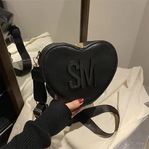 Fashion heart shaped crossbody bag in black leather with SM logo and nylon strap