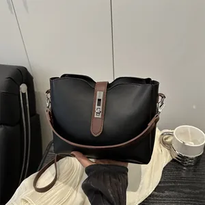 Grande borsa a secchiello nera con tracolla marrone e chiusura girevole in argento