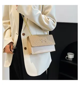 Detailed close-up of a beige bow handbag featuring woven texture and gold chain strap