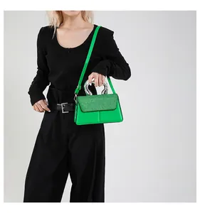 Detail of glitter sequins and unique silver metallic double handle on green handbag