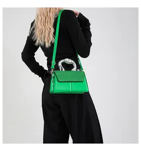Detail of green leather handbag with sparkling sequins and unique silver metal handle