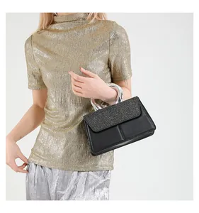 Detail of black crossbody bag with sparkling rhinestone flap and silver metal ring handle