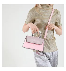 Pink crossbody bag with sequined flap detail and silver metal handle carried by model